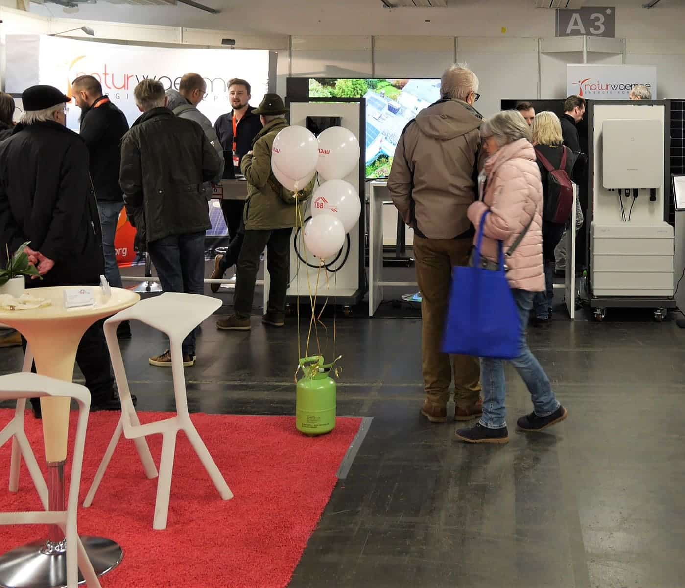 Messestand der Firma naturwaerme zu sehen mit Produkten und Interessenten auf der Baumesse Offenbach 2023.