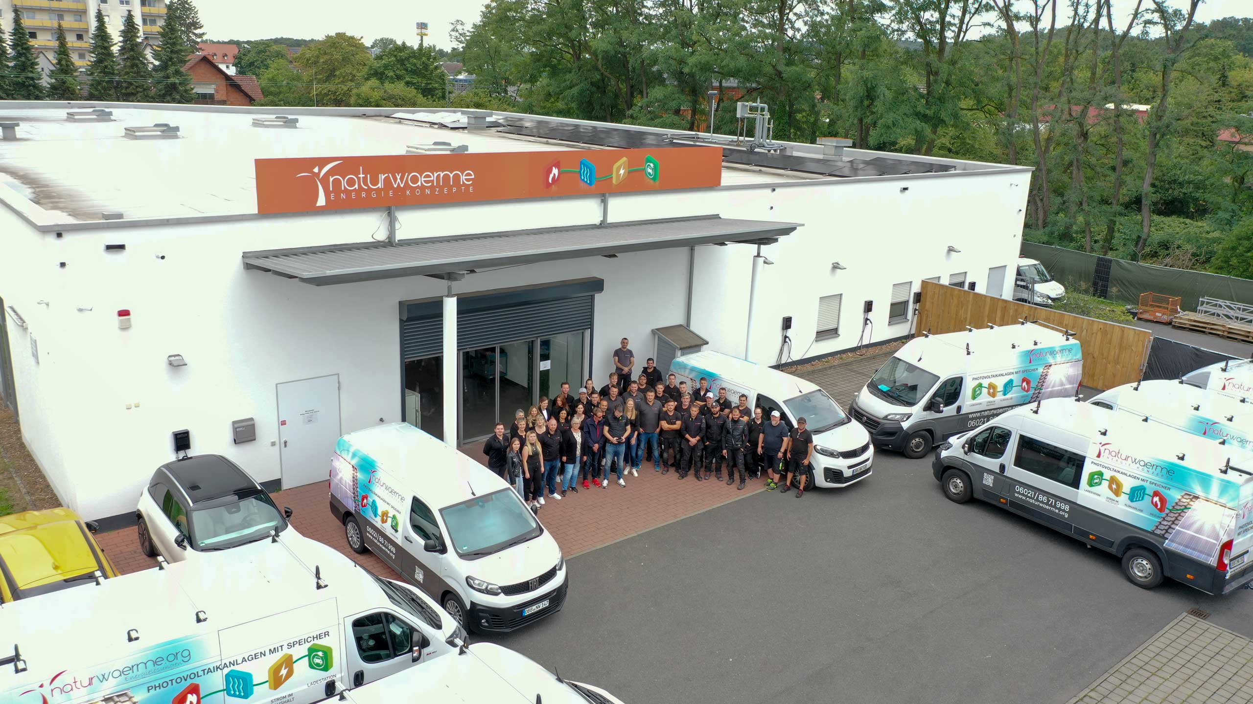 Teambild von naturwaerme mit Fahrzeugen aufgenommen vor dem naturwaerme Lager in Mainaschaff.