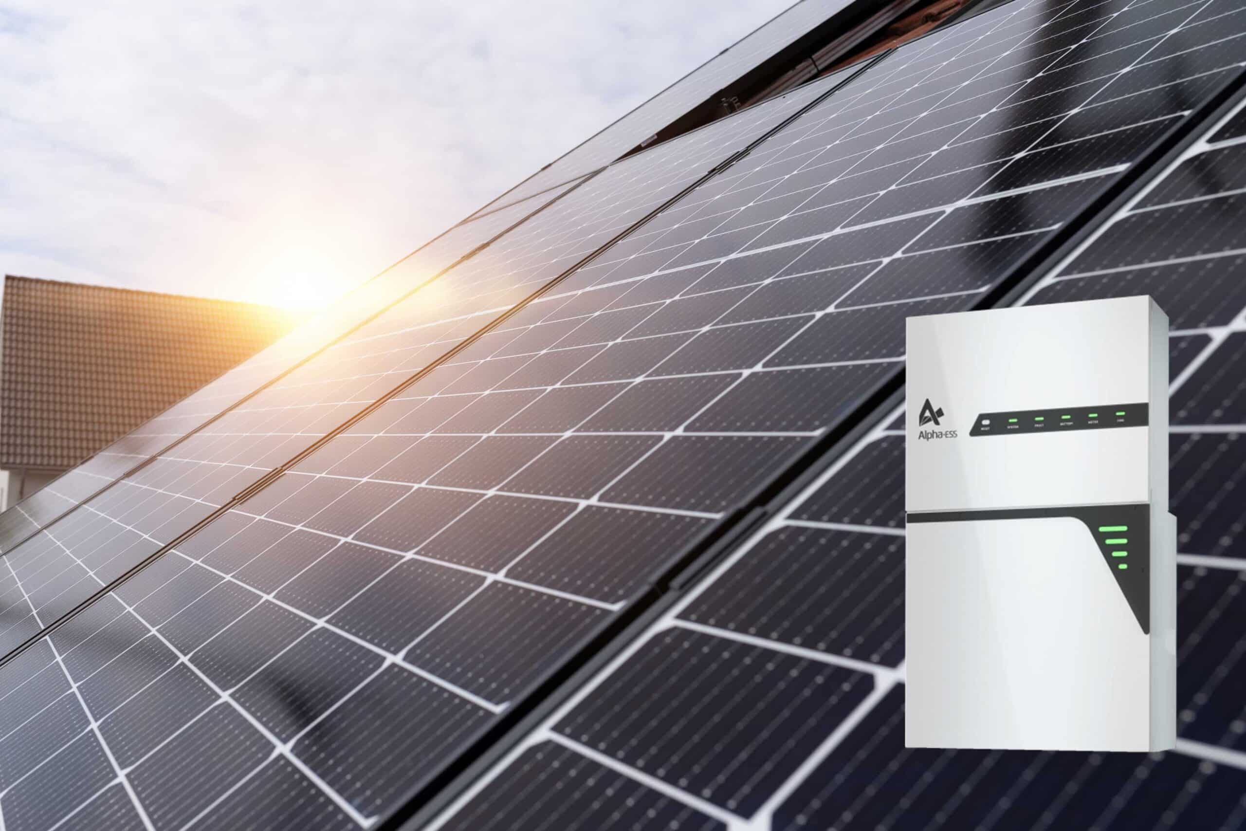 Alpha Batteriespeicher in Weiß zu sehen und dahinter Hausdach mit Solarmodulen.