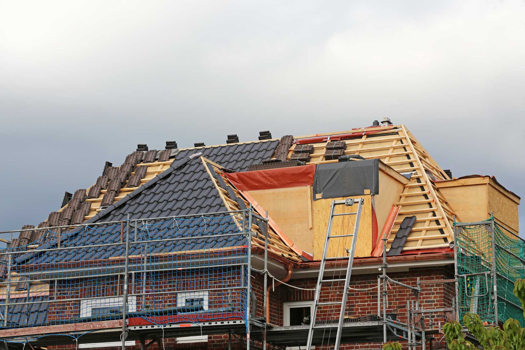 Haus welches mit neuen Dachziegeln eingedeckt wird.