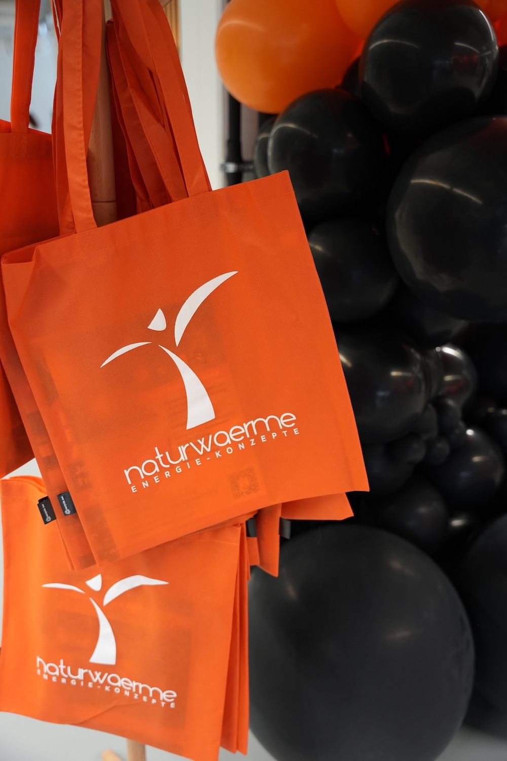 Neueroeffnung01289 Orangefarbene Werbetaschen von naturwaerme