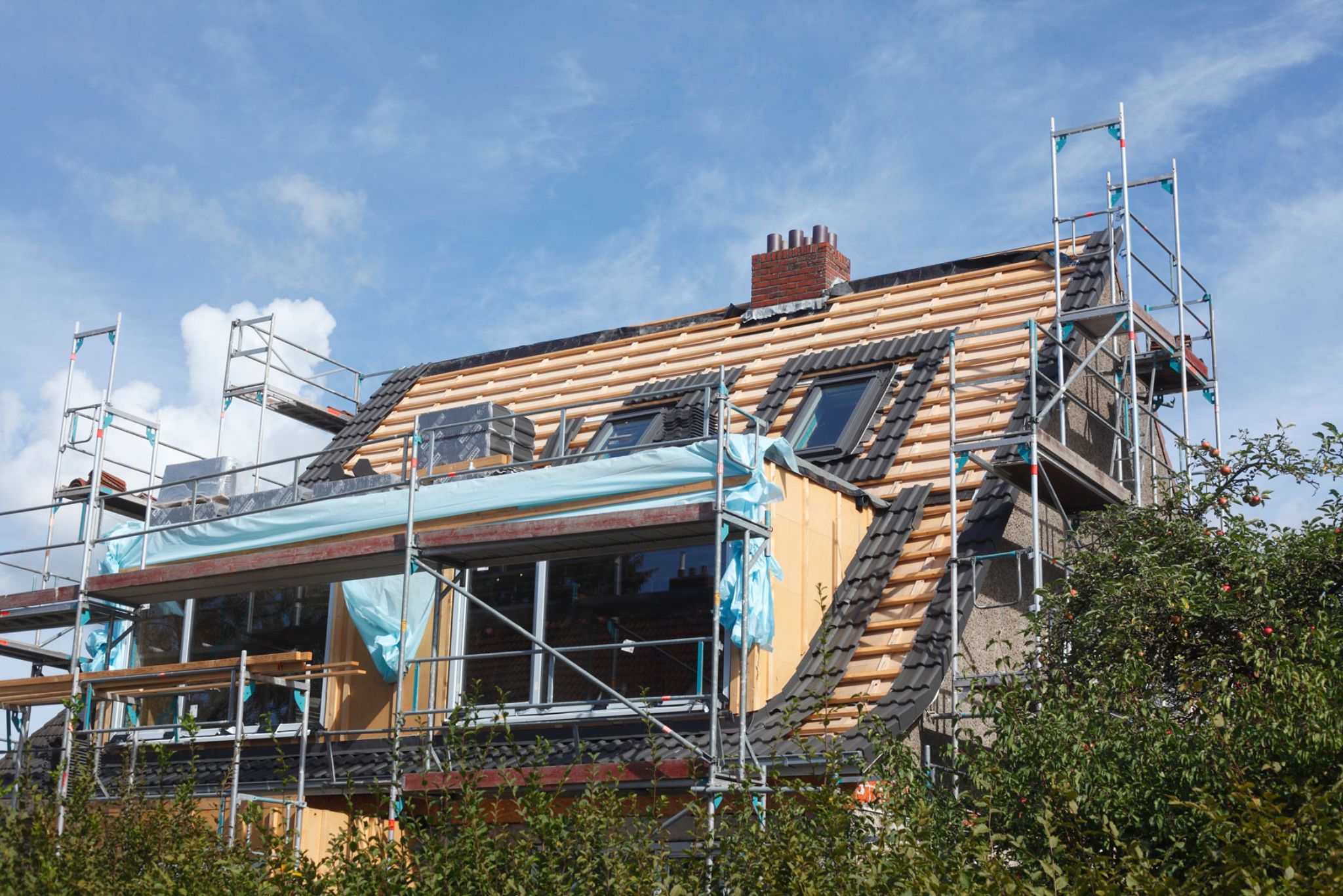 Haus mit Gerüst und fehlenden Dachziegeln