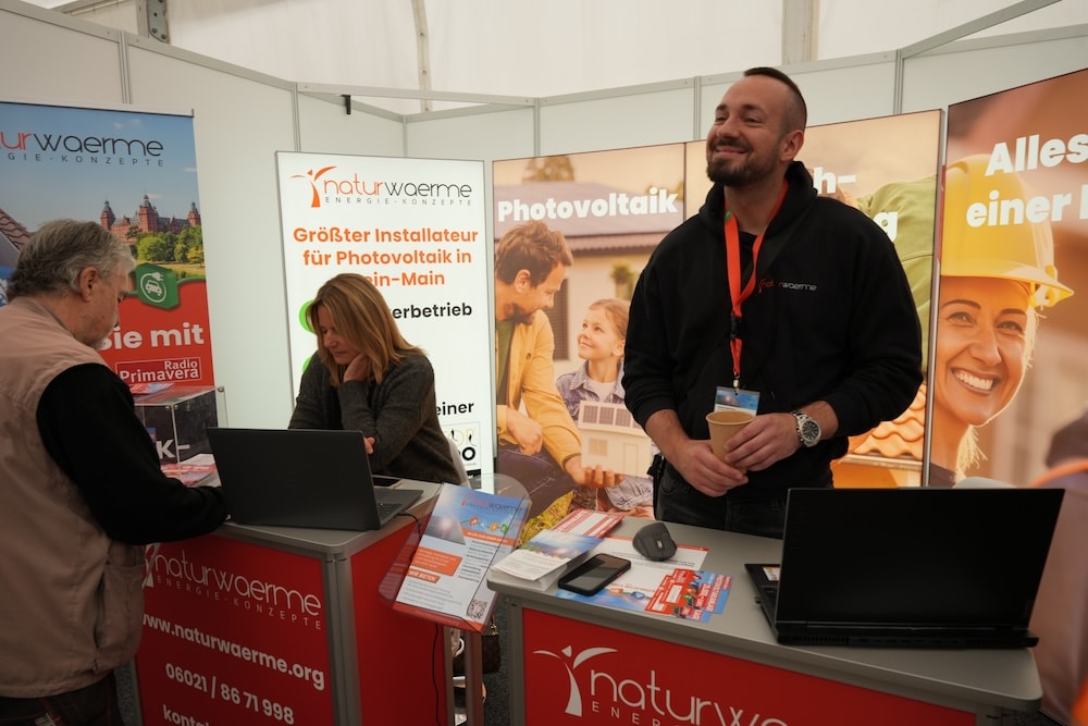 Gewinnspiel Wächtersbach04211 Frau und lachender Mann beraten auf Photovoltaik Messestand