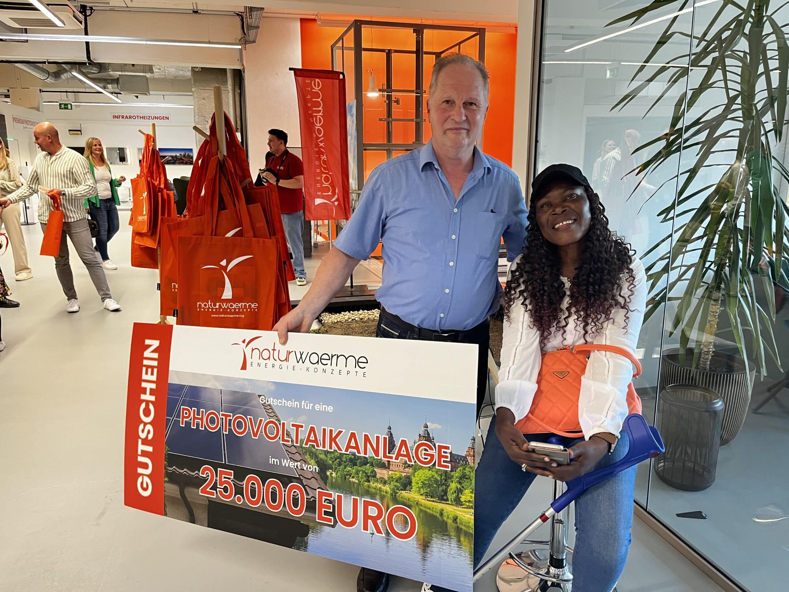 Mann mit Frau hält Scheck im Wert von 25.000 Euro einer Photovoltaikanlage in den Händen