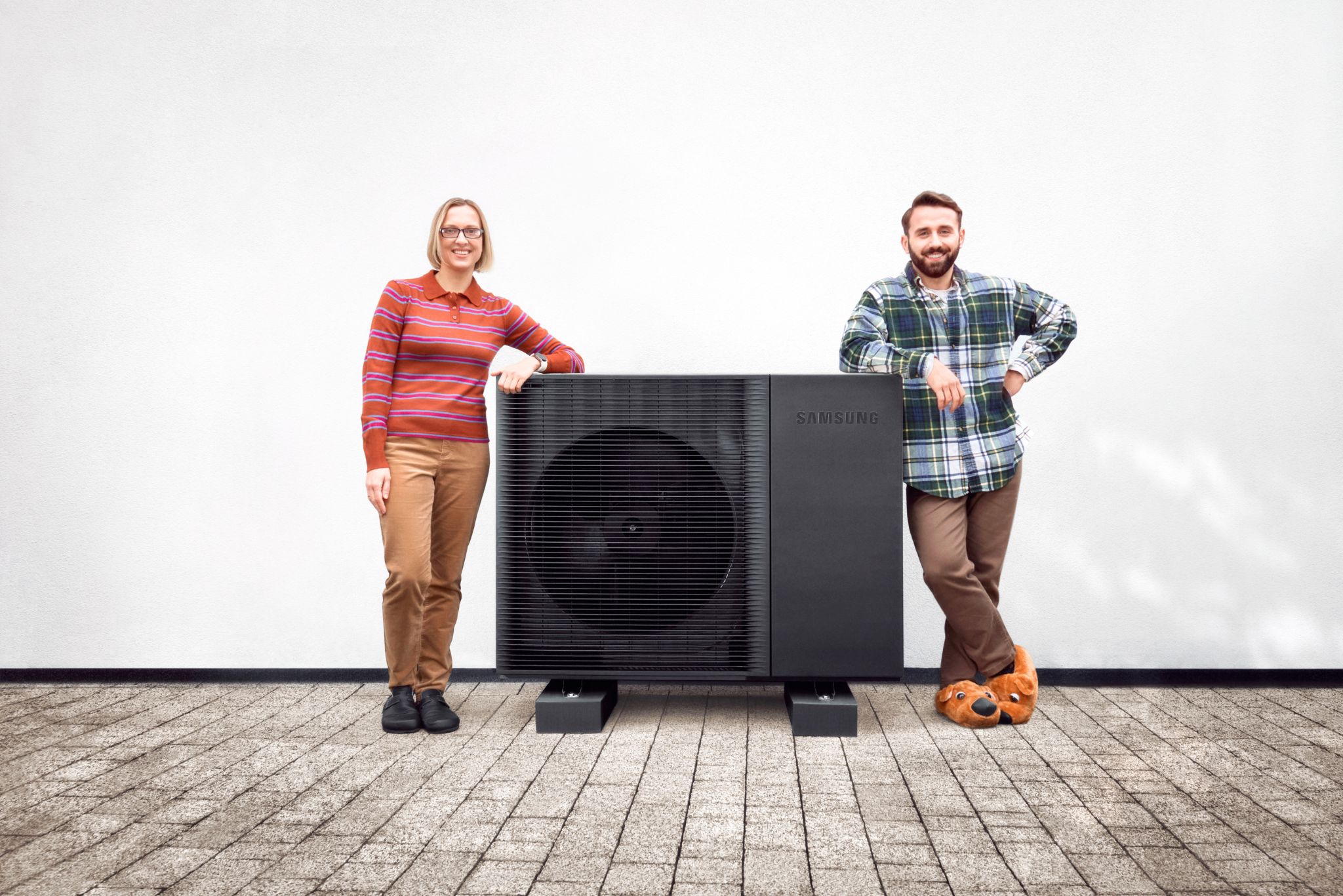 Zwei Menschen stehen neben einer Samsung Wärmepumpe