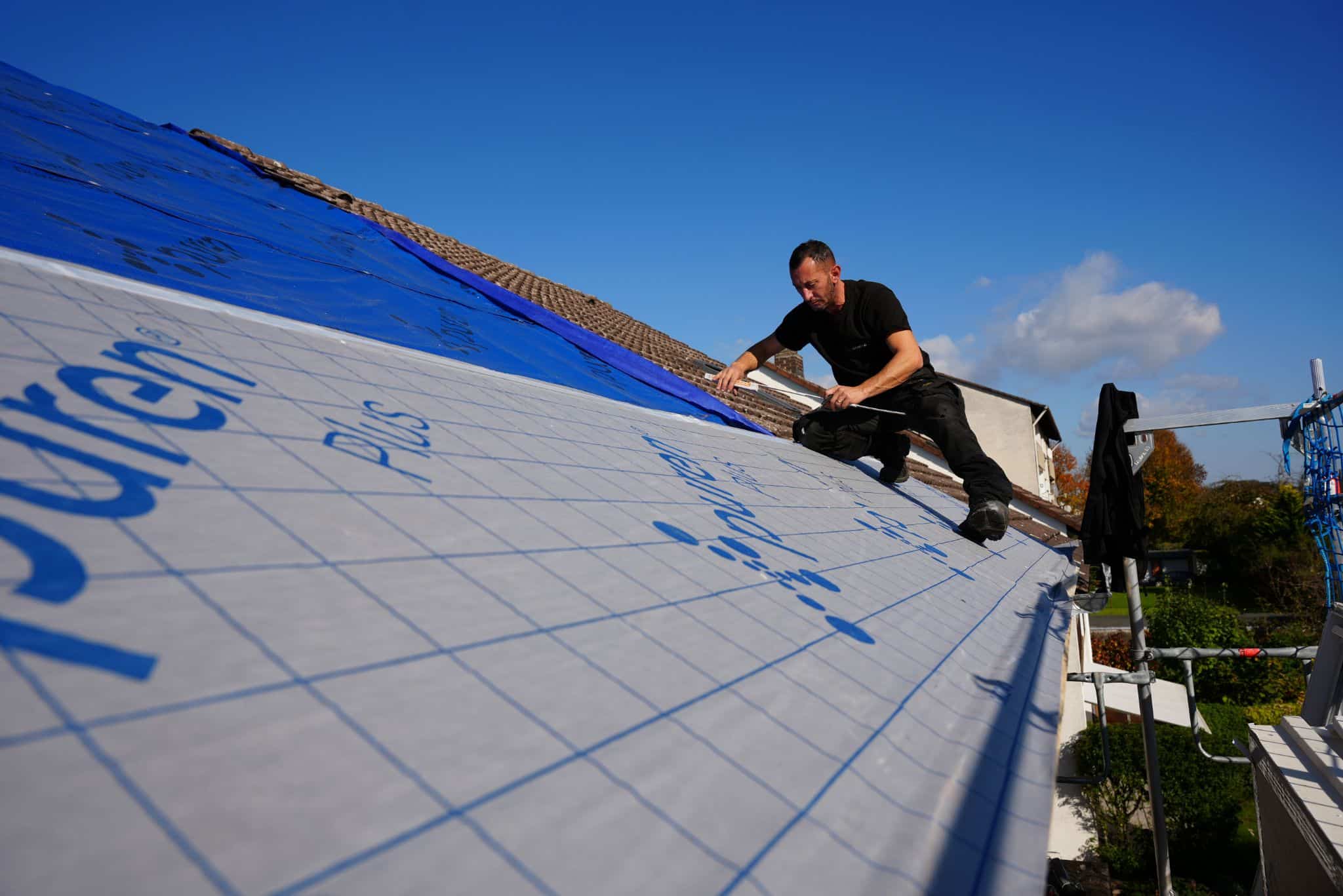 Dachdecker bei Dachsanierung, dämmt das Dach