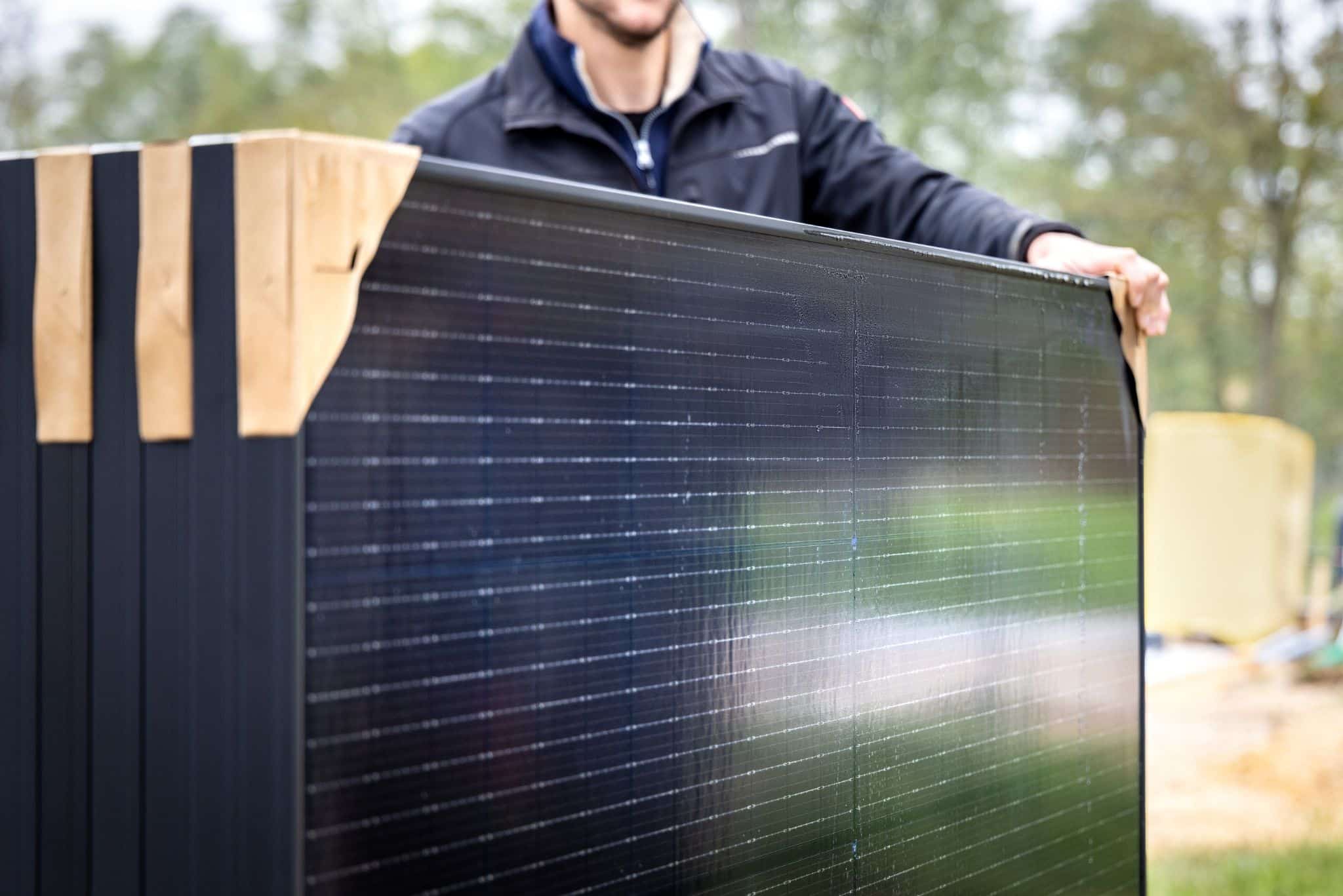 Mann trägt Solarmodule