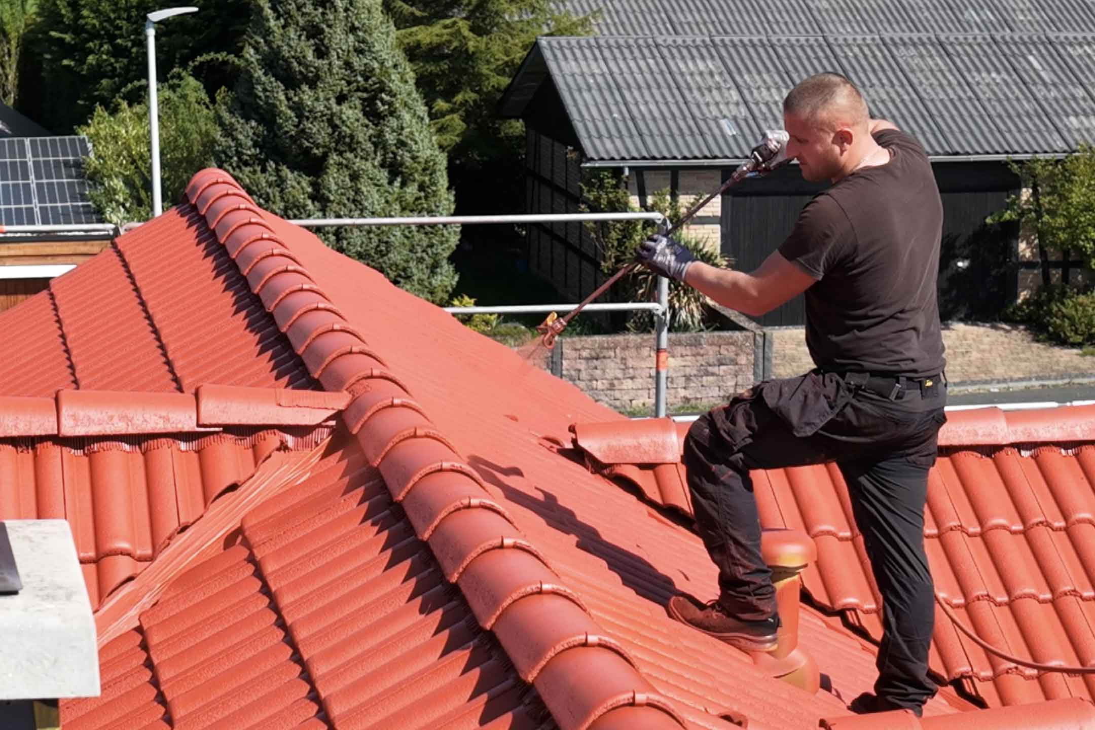 Dachbeschichtung-von-Naturwaerme Arbeiter auf einem Dach macht eine Dachbeschichtung von naturwaerme